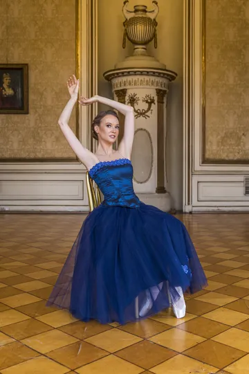 Ballet dancer in a blue dress in a historic hall